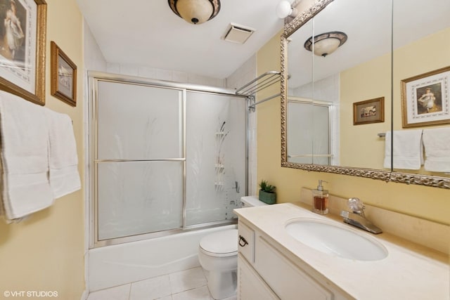 bathroom with toilet, combined bath / shower with glass door, tile patterned flooring, and vanity
