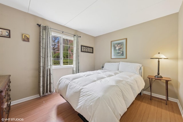bedroom with baseboards and wood finished floors