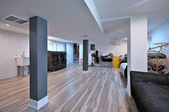 living room with washer and dryer, light wood-style floors, and baseboards