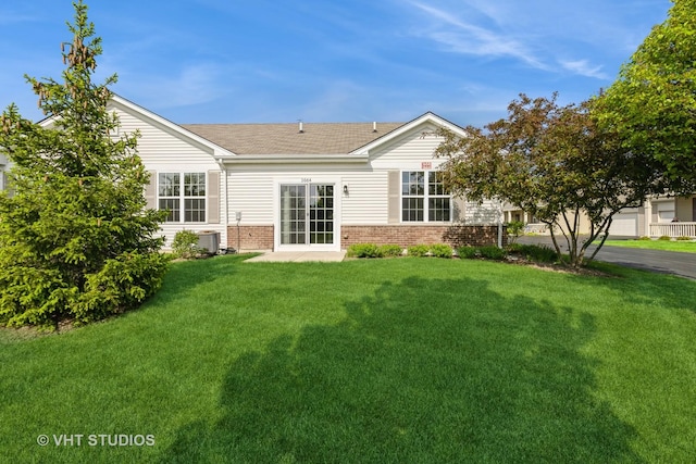 back of house with brick siding, a yard, central AC, and a shingled roof