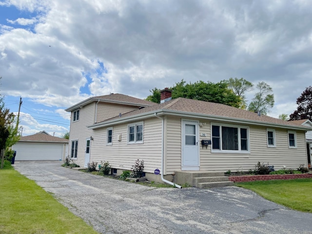 1908 Linden Ave, Waukegan, IL 60087 - view of front of home featuring an outbuilding, a chimney, a garage, a shingled roof, and a front yard