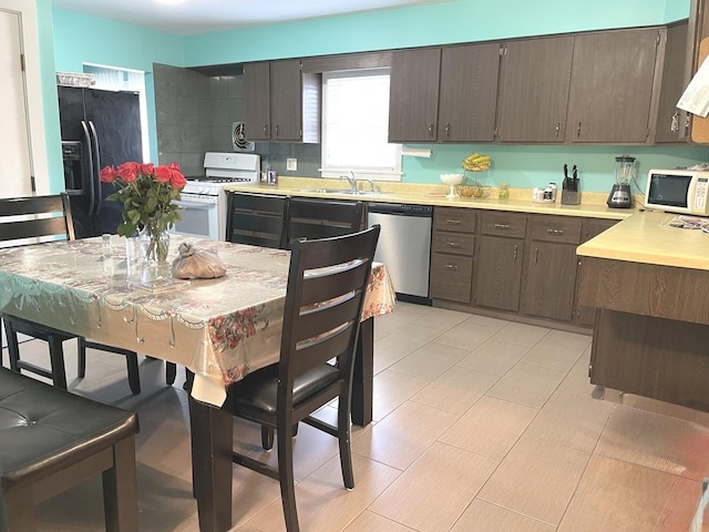 1908 Linden Ave, Waukegan, IL 60087 - kitchen with white appliances, light countertops, dark brown cabinets, and a sink