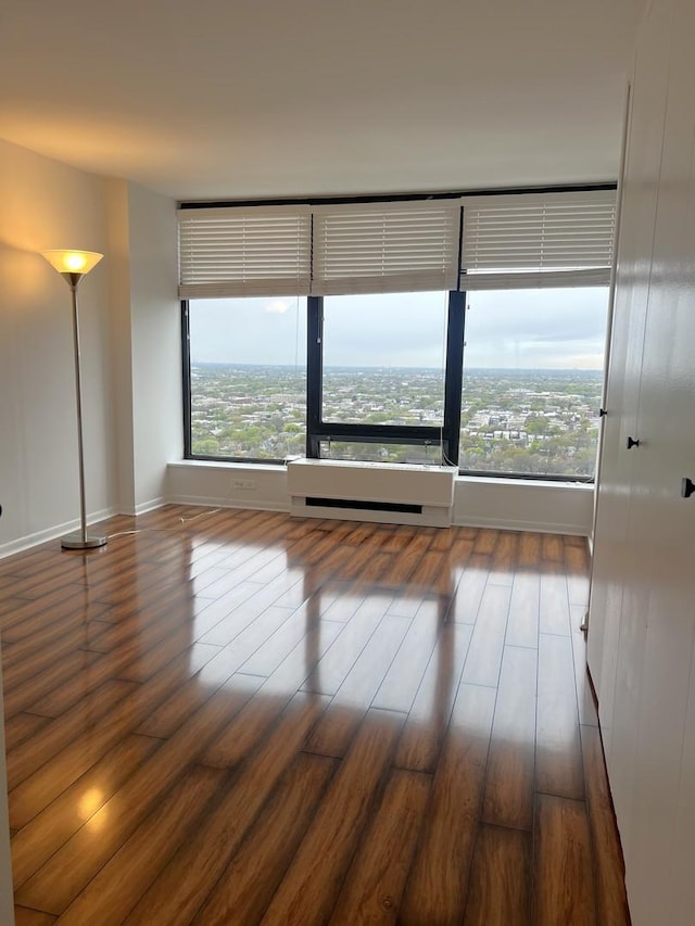 unfurnished room featuring wood finished floors and baseboards