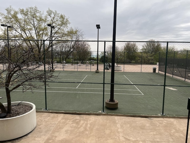 view of tennis court featuring fence