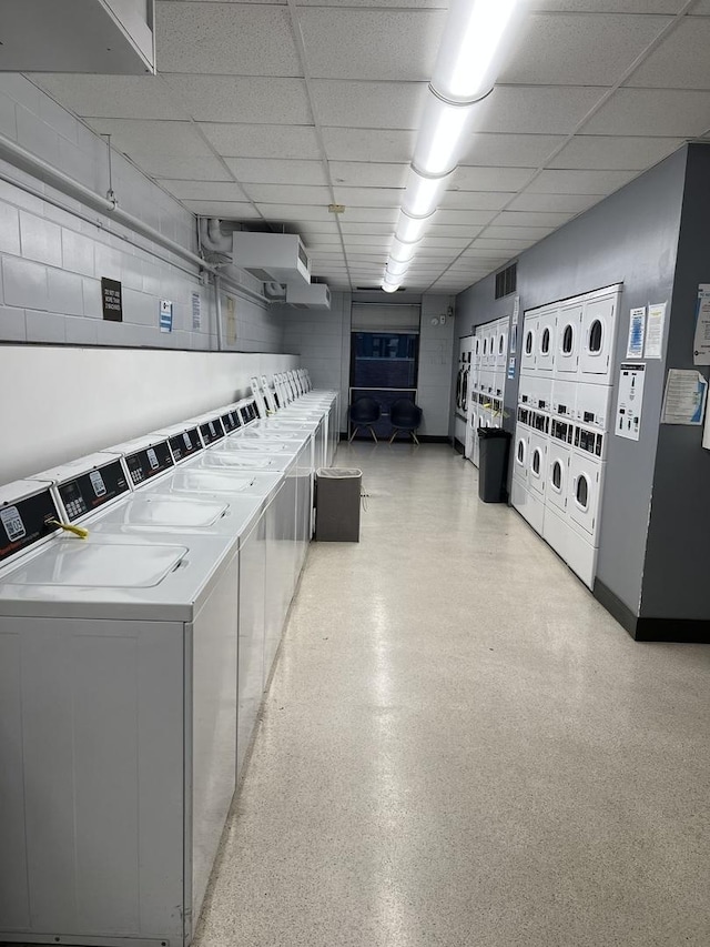 shared laundry featuring estacked washer and dryer, washer and dryer, and baseboards