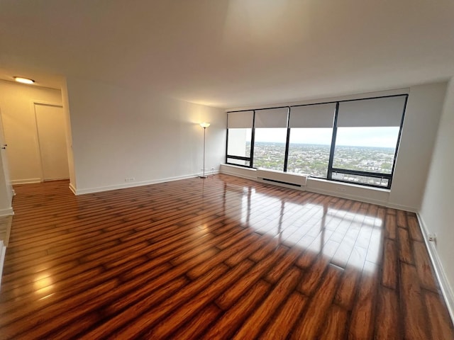 unfurnished room with dark wood-style floors and baseboards