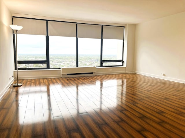 spare room featuring wood finished floors and baseboards