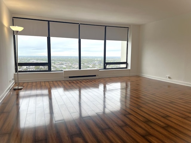 unfurnished room featuring dark wood-type flooring and baseboards