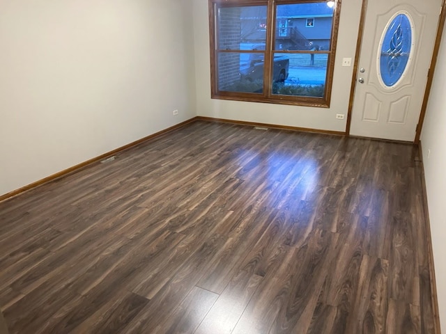 foyer entrance featuring dark wood-style floors and baseboards