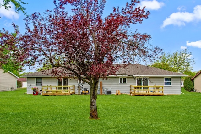 rear view of house featuring a wooden deck, a yard, and cooling unit
