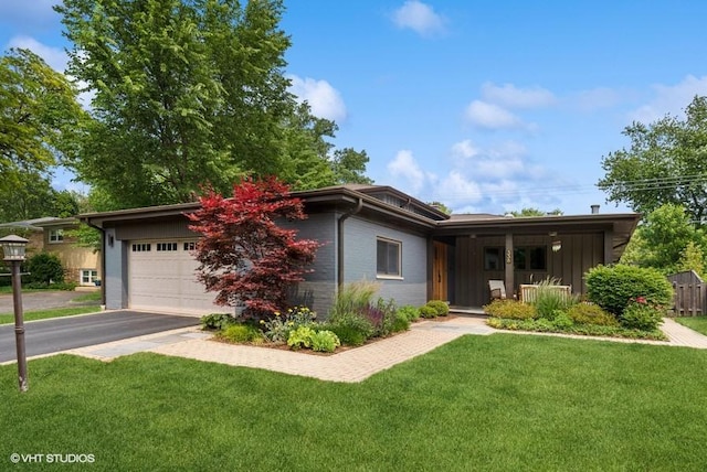 view of front facade featuring a garage, a front lawn, driveway, and board and batten siding