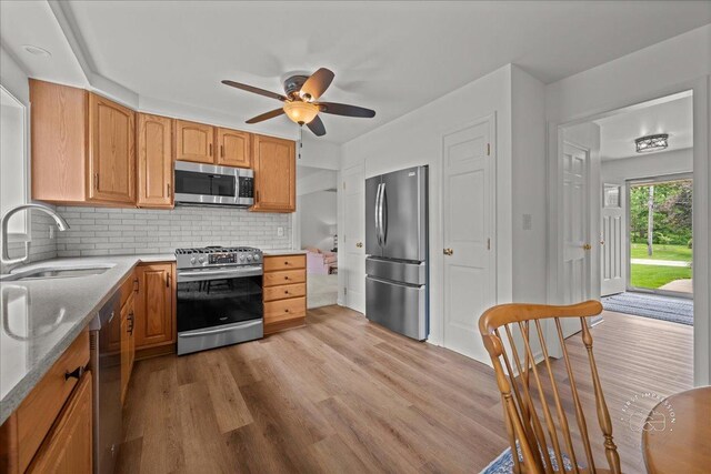 505 Waubonsee Trl, Batavia, IL 60510 - kitchen featuring stainless steel appliances, a sink, ceiling fan, light wood finished floors, and backsplash