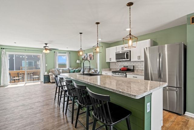 824 Briar Glen Ct, Hampshire, IL 60140 - kitchen featuring stainless steel appliances, a sink, an island with sink, white cabinets, and a breakfast bar
