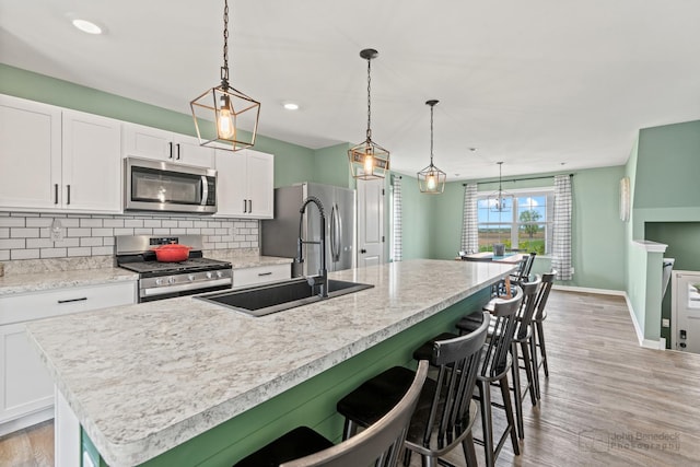 824 Briar Glen Ct, Hampshire, IL 60140 - kitchen with stainless steel appliances, a center island with sink, white cabinets, decorative backsplash, and a sink