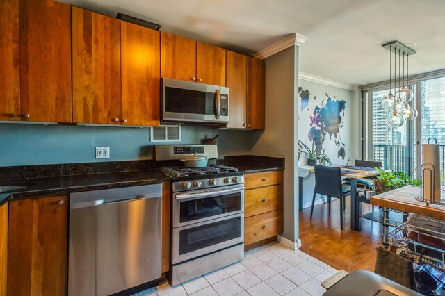 400 E Randolph St Unit 3918, Chicago, IL 60601 - kitchen with stainless steel appliances, ornamental molding, light tile patterned floors, brown cabinetry, and a chandelier
