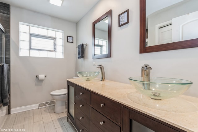 1080 E Prairie Ave, Des Plaines, IL 60016 - bathroom featuring healthy amount of natural light, baseboards, toilet, and double vanity