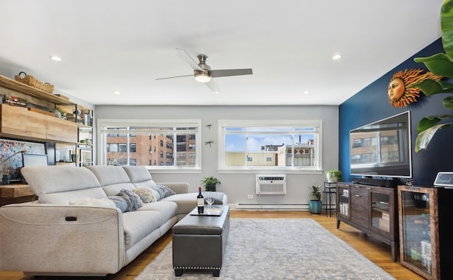 living room with healthy amount of natural light, an AC wall unit, wood finished floors, and recessed lighting