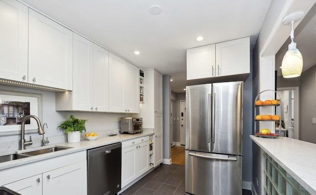 kitchen featuring stainless steel appliances, a sink, open shelves, light countertops, and white cabinetry
