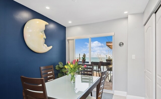 dining area with recessed lighting, baseboards, and a water view