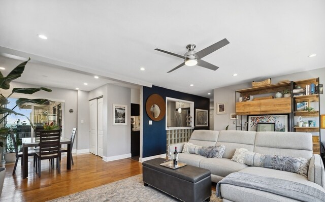 living area featuring wood finished floors, ceiling fan, recessed lighting, and baseboards