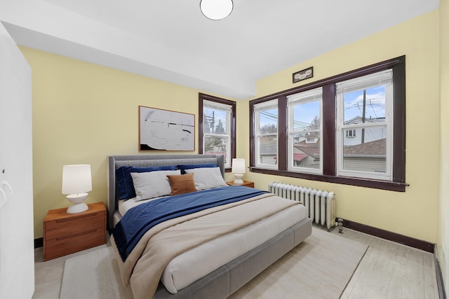 5019 N Kostner Ave, Chicago, IL 60630 - bedroom with radiator heating unit, baseboards, and light wood-style flooring