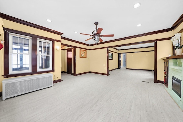 5019 N Kostner Ave, Chicago, IL 60630 - unfurnished living room featuring radiator heating unit, crown molding, baseboards, a brick fireplace, and a ceiling fan