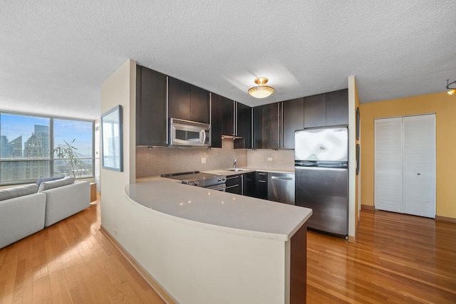 405 N Wabash Ave Unit 4709, Chicago, IL 60611 - kitchen featuring stainless steel appliances, a sink, light countertops, light wood finished floors, and a textured ceiling