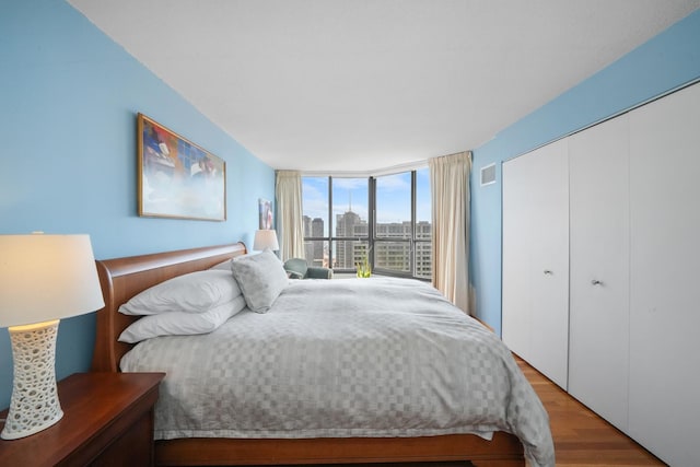 405 N Wabash Ave Unit 4709, Chicago, IL 60611 - bedroom with light wood-type flooring, a closet, a view of city, and a wall of windows