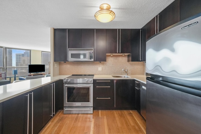 405 N Wabash Ave Unit 4709, Chicago, IL 60611 - kitchen with stainless steel appliances, a sink, light countertops, light wood-style floors, and a textured ceiling