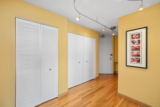 405 N Wabash Ave Unit 4709, Chicago, IL 60611 - unfurnished bedroom featuring two closets, light wood-style flooring, and track lighting