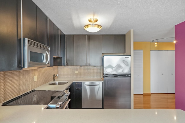 405 N Wabash Ave Unit 4709, Chicago, IL 60611 - kitchen with stainless steel appliances, a sink, decorative backsplash, light countertops, and light wood-style floors