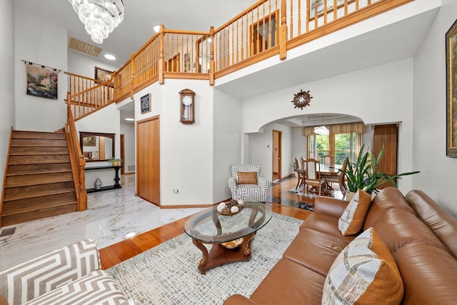 11731 Blackburn Dr, Orland Park, IL 60467 - living room with arched walkways, a towering ceiling, baseboards, stairs, and a chandelier