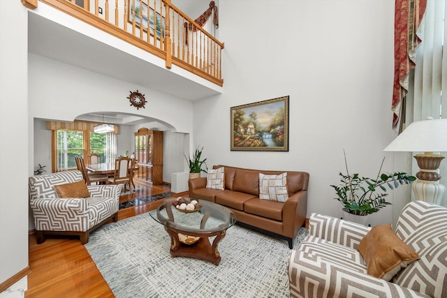 11731 Blackburn Dr, Orland Park, IL 60467 - living area with arched walkways, a high ceiling, wood finished floors, and baseboards