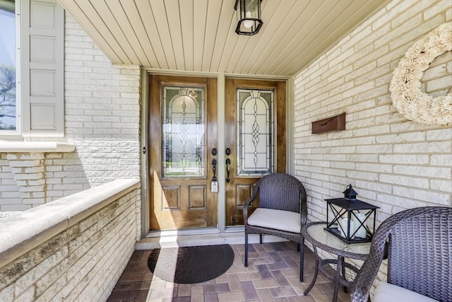 doorway to property featuring brick siding