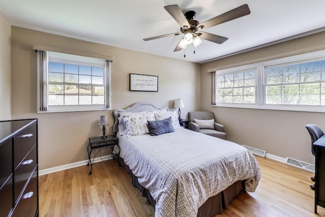 bedroom featuring baseboards, light wood-style floors, and a ceiling fan