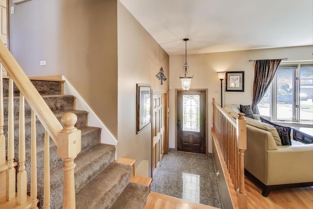 entryway featuring plenty of natural light, stairs, and baseboards