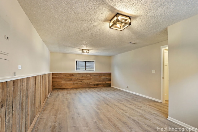 25269 W Anderson St, Ingleside, IL 60041 - spare room with wood finished floors, a textured ceiling, wooden walls, and a wainscoted wall