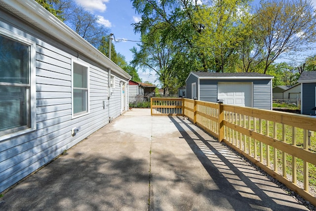 view of patio featuring a detached garage and an outbuilding