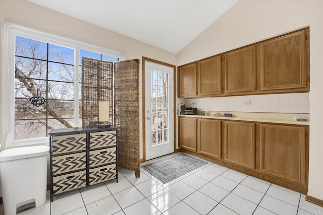 9056 W Heathwood Cir, Niles, IL 60714 - kitchen with brown cabinets, light countertops, lofted ceiling, and decorative backsplash