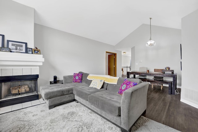 9056 W Heathwood Cir, Niles, IL 60714 - living area with a fireplace, vaulted ceiling, wood finished floors, and a chandelier