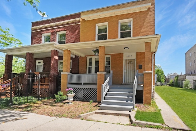 6409 S Champlain Ave, Chicago, IL 60637 - view of front facade with brick siding, a porch, and a front lawn