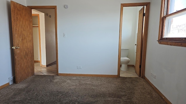 391 Mackinaw Ave, Calumet City, IL 60409 - unfurnished bedroom with light tile patterned floors, light carpet, and baseboards