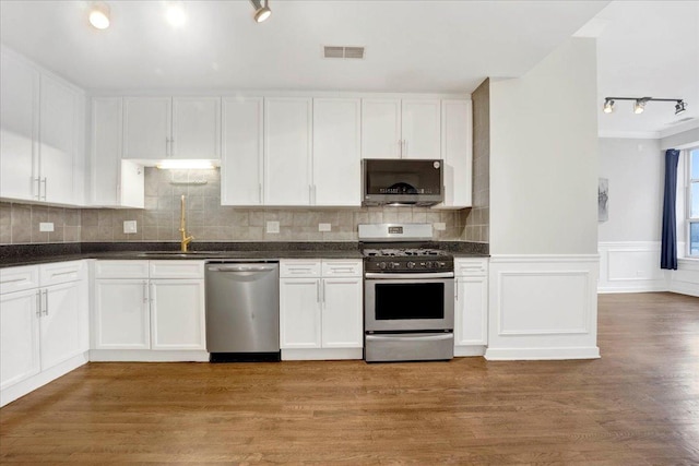 1910 S State St Unit 231, Chicago, IL 60616 - kitchen with appliances with stainless steel finishes, a sink, track lighting, white cabinets, and a wainscoted wall