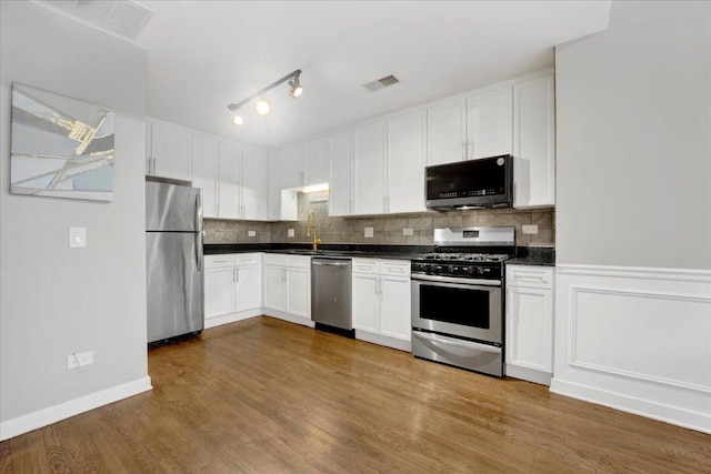 1910 S State St Unit 231, Chicago, IL 60616 - kitchen featuring appliances with stainless steel finishes, dark countertops, a sink, white cabinetry, and tasteful backsplash