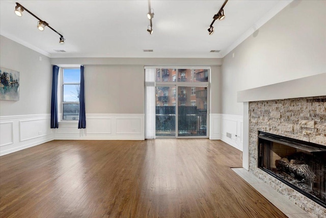 1910 S State St Unit 231, Chicago, IL 60616 - unfurnished living room with rail lighting, ornamental molding, a stone fireplace, wainscoting, and wood finished floors