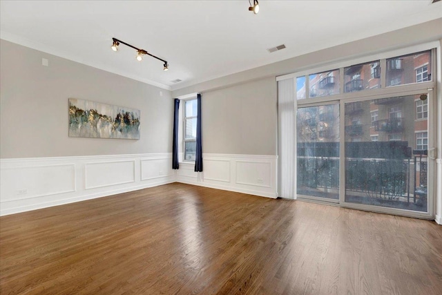 1910 S State St Unit 231, Chicago, IL 60616 - empty room featuring a wainscoted wall, wood finished floors, crown molding, and a decorative wall