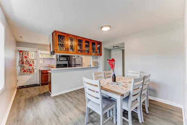 dining room featuring light wood-style flooring and baseboards