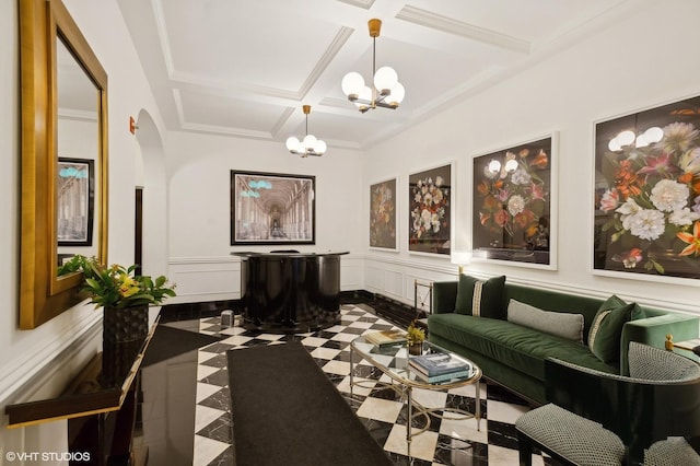 living area with a chandelier, coffered ceiling, a decorative wall, beamed ceiling, and wainscoting