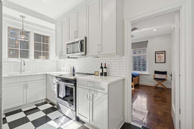 kitchen with appliances with stainless steel finishes, a sink, backsplash, baseboards, and recessed lighting