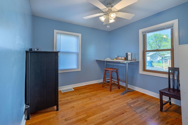 miscellaneous room with light wood-type flooring, a ceiling fan, and baseboards